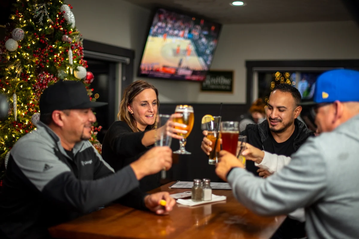 Friends raising their glasses together at Rewsters