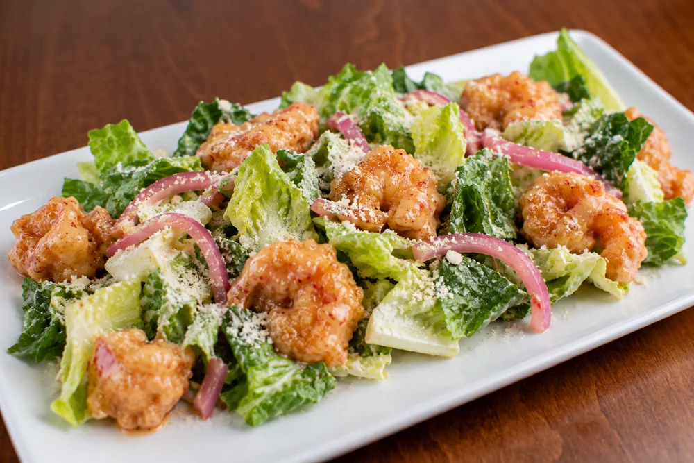 Bang Bang Shrimp salad with crispy shrimp, lettuce, parmesan, and pickled red onion