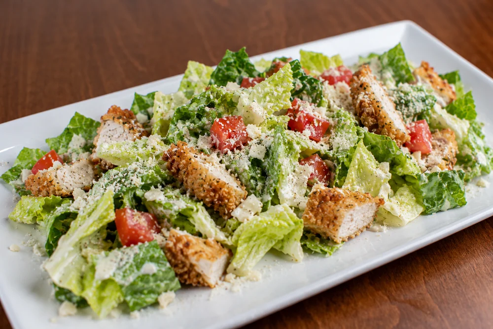 Classic Caesar salad with crispy chicken, lettuce, tomato, and parmesan