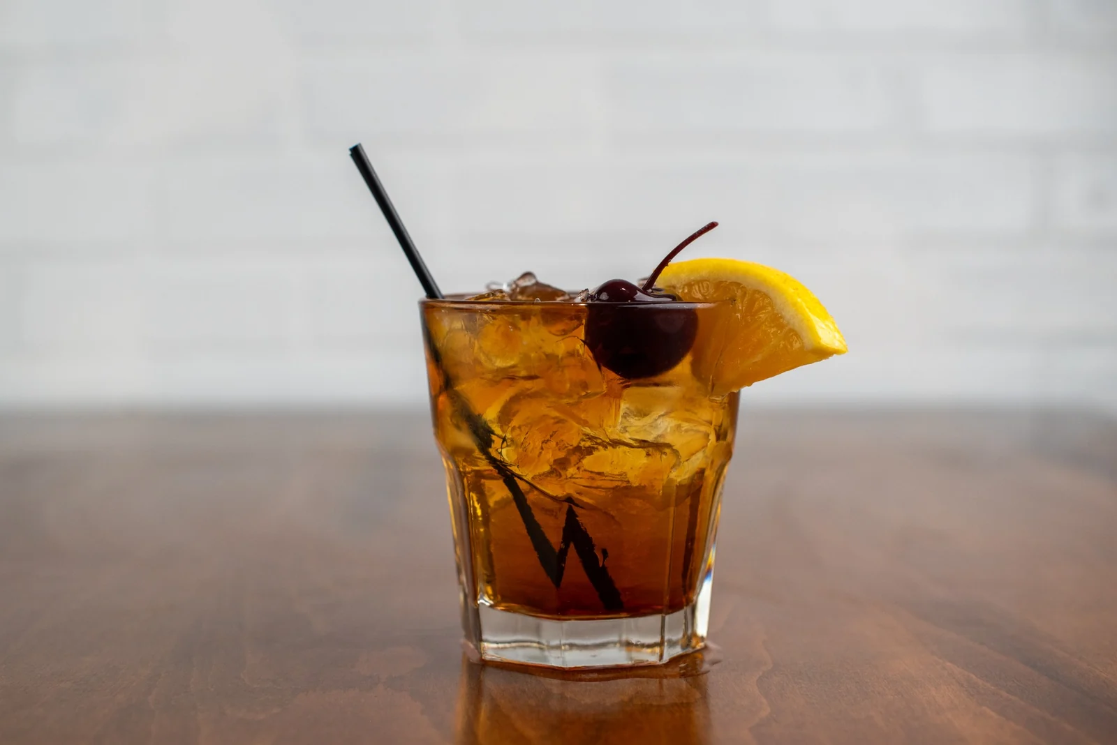 An Old Fashioned on the wood bar top